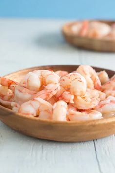 a bowl filled with shrimp sitting on top of a table