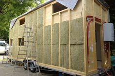 a house being built on the back of a truck with insulation taped to it's sides