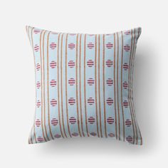 a blue and orange striped pillow on a white background with red circles in the middle