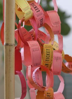 a bunch of pink and yellow ribbons hanging from a pole