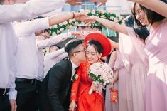 a group of people standing next to each other in front of a wedding ceremony arch