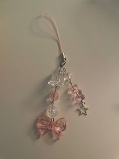 a pair of pink and clear glass beads hanging from a silver metal keychain