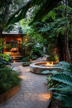 an outdoor garden with lots of plants and lights on the path leading to a house