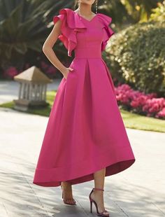 a woman in a pink dress posing for the camera