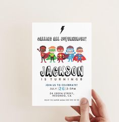 a hand holding up a birthday card with the name jackson and superheros on it