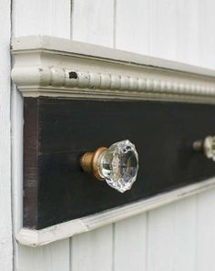 an old door handle with glass knobs on the side of a white wooden building