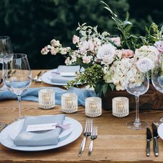 the table is set with flowers and silverware for an elegant wedding reception or special event