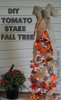 a diy tomato stake fall tree is decorated with lights and burlap ribbon