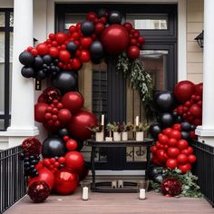 a red and black balloon arch on the front porch