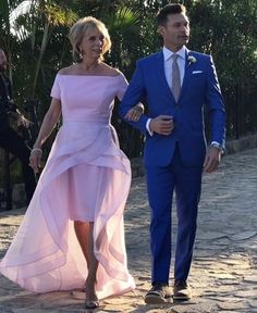 a man and woman in formal wear walking together