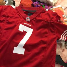 a football jersey with the number seven on it is laying next to other sports items