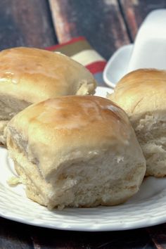 three biscuits sitting on top of a white plate