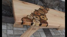 a wooden bench sitting on top of a stone floor next to a tree trunk covered in wood