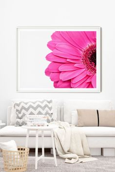 a living room filled with furniture and a large pink flower on the wall above it