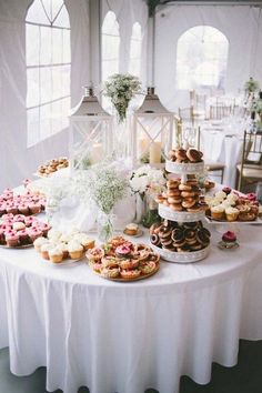 a table topped with lots of cupcakes and cakes