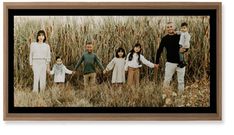 a family standing in tall grass holding hands