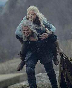 a woman carrying a man on her back