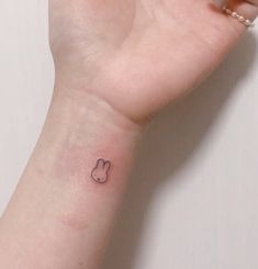 a person's hand with a small tattoo on the middle of their left wrist