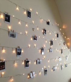 there are many pictures hanging on the wall with string lights strung from it and photos pinned to the wall