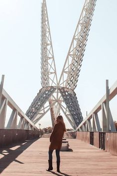 a person standing on a bridge looking up at the sky