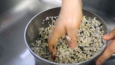 a person is scooping seeds into a metal bowl