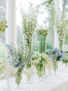 there are many vases with flowers on the table