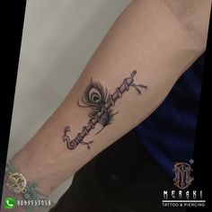 a tattoo on the arm of a person with an evil eye and feathered tail