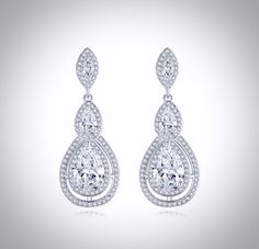 A delightfully unique pair of bridal earrings with an incredible sparkle! Adorned with flawlessly faceted cubic zirconia that capture the light in a dazzling array of sparkles, the earrings are rhodium plated for a bright finish which enhances the intricate detailing and conveys a modern take on old elegance. Overall length of the earring is 1.5" (approx. 4cm). Available in Silver, Rose Gold and Yellow Gold finishes. To make your choice select your preferred finish from the dropdown menu to add Elegant Diamond White Crystal Earrings With Halo Design, Dazzling Cubic Zirconia Crystal Earrings With Halo Design, Formal Cubic Zirconia Crystal Earrings With Halo Design, Formal Halo Design Crystal Earrings With Cubic Zirconia, Brilliant Cut Teardrop Chandelier Earrings With Cubic Zirconia, Teardrop Chandelier Earrings In Cubic Zirconia With Brilliant Cut, Glamorous Brilliant Cut Bridal Earrings, Diamond White Brilliant Cut Cubic Zirconia Bridal Earrings, Brilliant Cut Crystal Drop Diamond Earrings