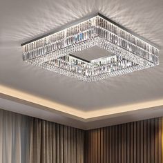 a square crystal chandelier hanging from the ceiling in a room with curtains and drapes