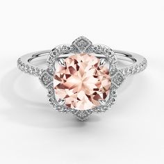 a pink diamond ring with diamonds around it