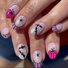 a woman's nails with spider webs and pink nail polishes on them