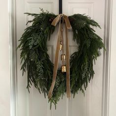 a wreath with bells hanging on the front door