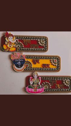 three small decorative items on a white surface, one with ganeshi and the other with lord ganeshi