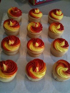 there are many cupcakes that have been decorated with red and yellow icing