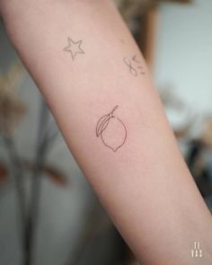 a small tattoo on the arm of a woman's left arm, with stars above it