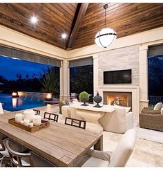 a dining room table with candles on it in front of a large window overlooking a swimming pool