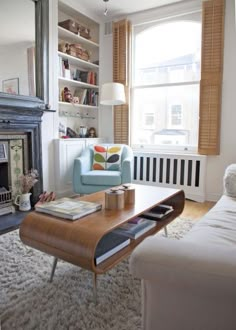 a living room filled with furniture and a fire place in front of a large window