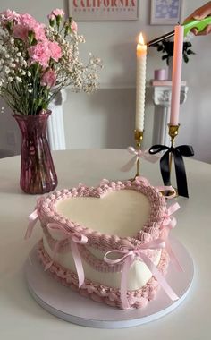 a cake sitting on top of a table next to a vase filled with flowers