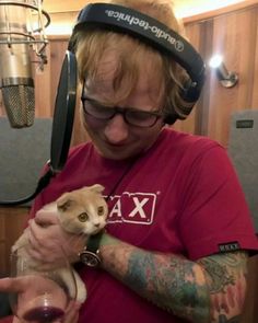 a man with headphones on holding a cat