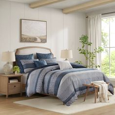 a bed with blue and white comforters in a room