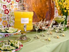 a table topped with plates and glasses filled with fruit next to a vase full of flowers