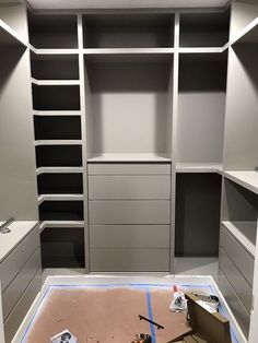 an empty walk in closet with lots of shelves and drawers on the floor, including tools