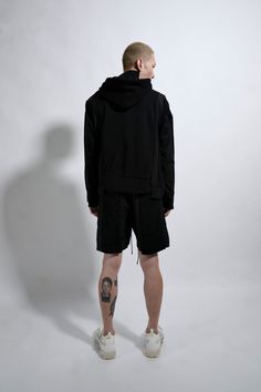 Black cotton french terry/nylon spliced seam oversized drop shoulder pullover hoodie with asymmetrical zipper closure, large branded HD print and staggered hem detailing HIGHLIGHTS * Cotton french terry and nylon sourced from Japan  * Oversized, drop shoulder pullover spliced seam hoodie with 'track jacket' detailed inserts * Asymmetrical zipper closure * Large branded tonal HD print * Staggered hem detailing * MHRS signature tyvek barcode on wearer's upper left chest COMPOSITION * 100% Cotton  * 100% Nylon Above The Knee Shorts, Hd Print, Track Jacket, Track Jackets, Hat Sizes, Denim Pants, Black Hoodie, French Terry, Short Pants