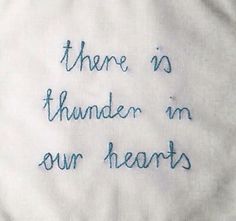 there is no thunder in our hearts embroidered on a white piece of cloth with blue thread