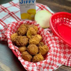 a basket filled with fried food next to a container of milk and an apple slice