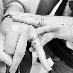 two people holding hands with rings on their fingers