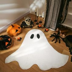 halloween decorations including a ghost rug, candles and pumpkins