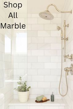 a white tiled bathroom with a shower head