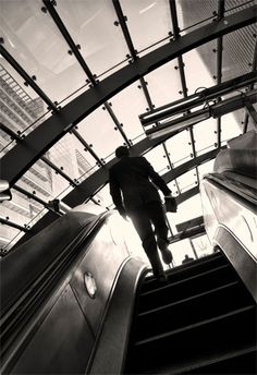 a man is walking down an escalator in a building