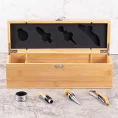 an open wooden box with four different types of hair tools in it on a marble surface